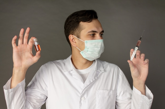 trabajador médico tiene una vacuna y usa una máscara para protegerse del coronavirus