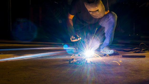 Trabajador de metal de soldadura, se centran en la luz de flash línea de chispa fuerte en baja luz