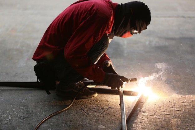 Foto trabajador metalúrgico ceñido de soldadura en curso