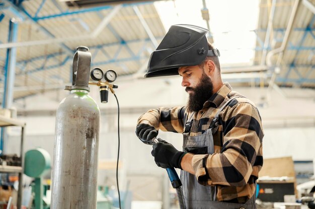 Un trabajador metalúrgico que prepara el soldador para trabajar en la fábrica.