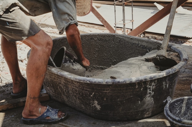 Trabajador mezcla de yeso de mortero de cemento para la construcción