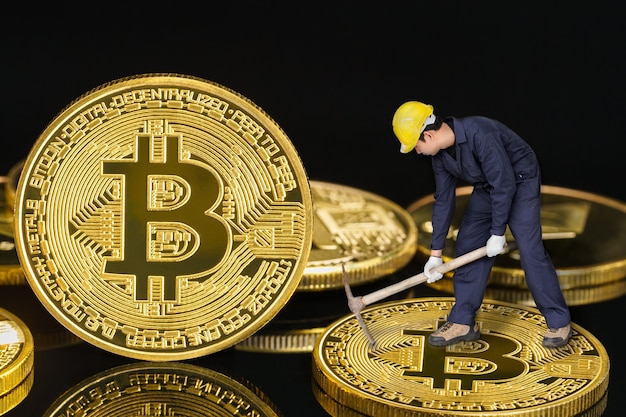 Trabajador de la minería de bitcoin sosteniendo azadón excavando bitcoin dorado sobre fondo negro