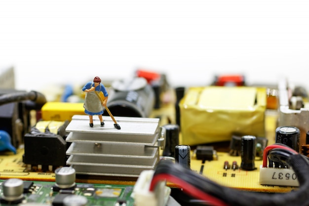 Trabajador en miniatura limpieza de la computadora de la placa base.