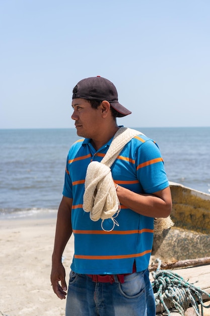 Trabajador mirando hacia otro lado mientras lleva una red de pesca