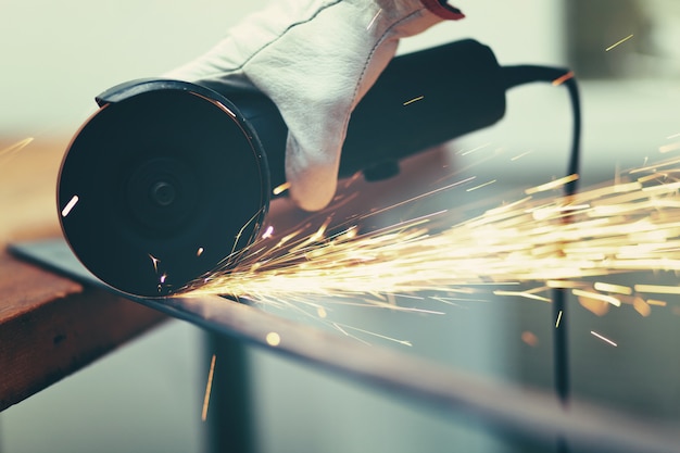 Foto trabajador moliendo una placa de metal