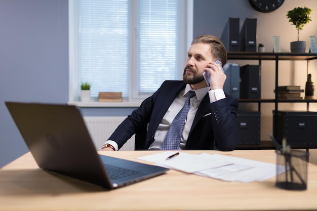 trabajador de oficina maduro teniendo una conversación telefónica