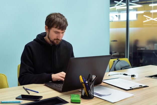 Trabajador de oficina sentado en la mesa de la oficina trabajando en una computadora portátil consultando capacitación distancia comercial