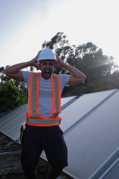 trabajador de panel solar desesperado grita con las manos en la cabeza.