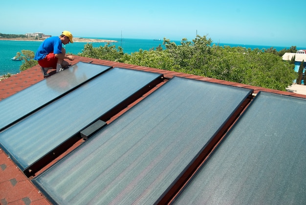 Trabajador paneles solares de calentamiento de agua en el techo.