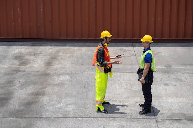 Trabajador del personal de pie y comprobando la caja de contenedores del buque de carga para exportación e importación