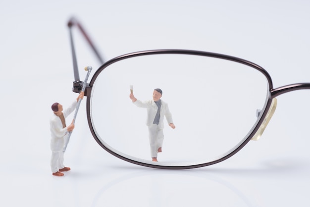 trabajador de personas en miniatura limpieza ojos gafas