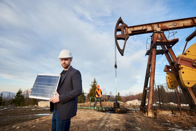 Trabajador petrolero en casco con panel solar