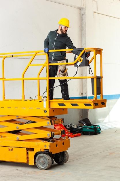 Foto trabajador de pie en una plataforma hidráulica