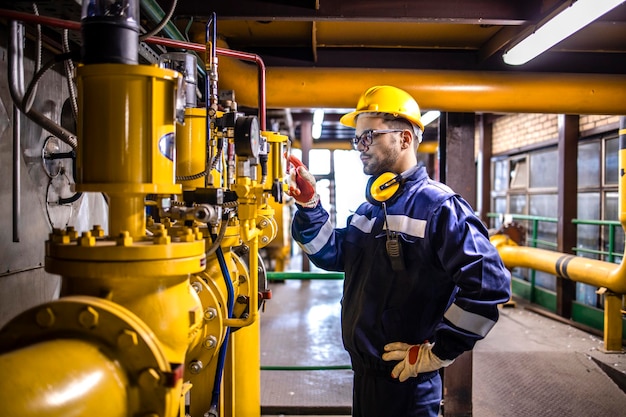 Trabajador de la planta de energía de gas natural que controla la producción de energía dentro de la fábrica