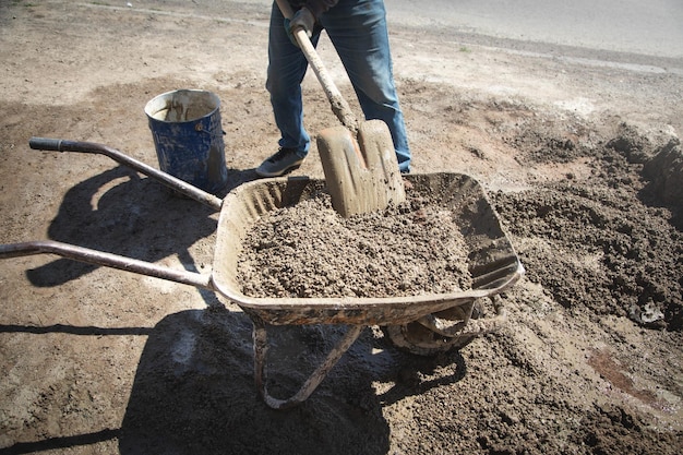 Trabajador preparar hormigón con pala en obra