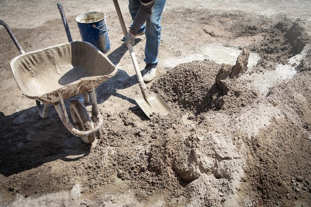 Trabajador preparar hormigón con pala en obra