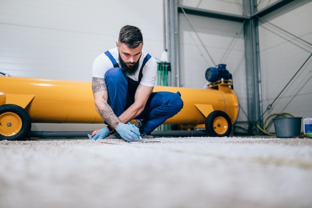 Trabajador profesional haciendo su trabajo en el servicio de lavado de alfombras.