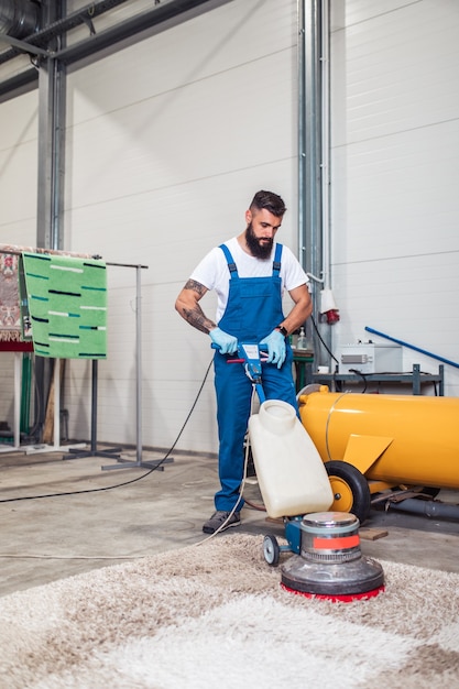 Foto trabajador profesional haciendo su trabajo en el servicio de lavado de alfombras.