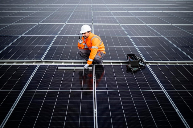 Trabajador profesional instalando paneles solares para una planta de energía sostenible