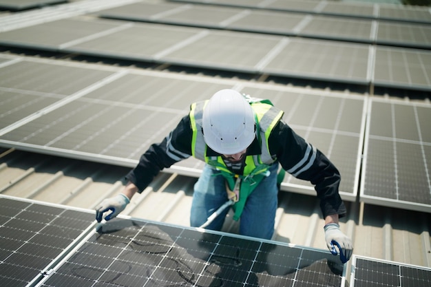 Trabajador profesional instalando paneles solares en el techo de una casa