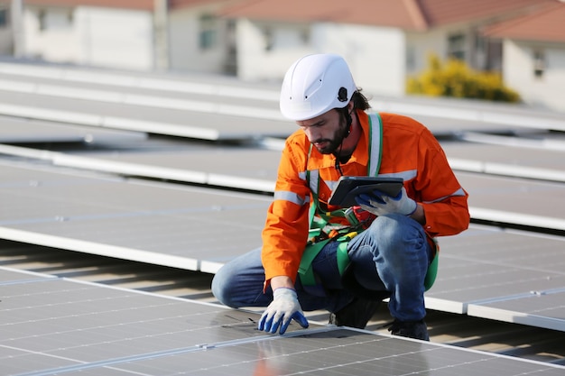 Trabajador profesional instalando paneles solares en el techo de una casa