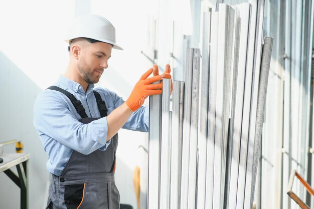 Trabajador profesional de telas Planta de procesamiento de metales Un trabajador en un almacén de perfiles metálicos