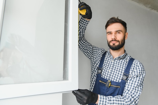 Trabajador que instala una ventana de plástico en el interior