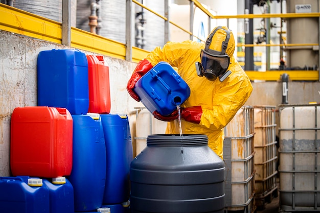 Trabajador químico o tecnólogo con traje de protección amarillo y máscara de gas que fabrica ácido sulfúrico