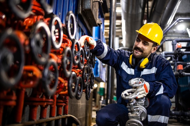 Foto trabajador de refinería de petróleo militar que cambia válvulas industriales