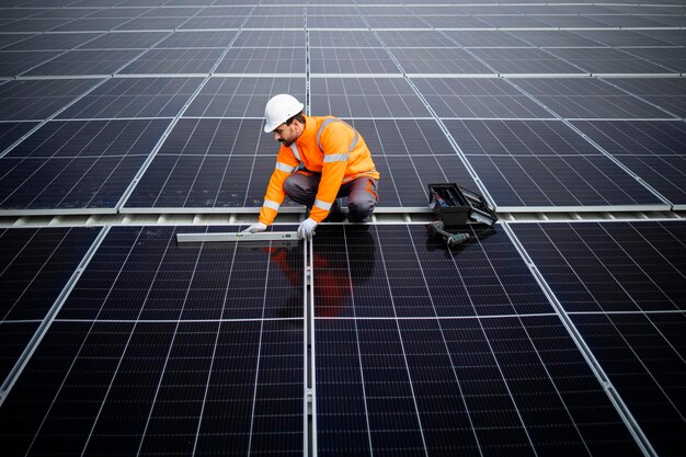 trabajador revisando el nivel e instalando módulos de paneles solares en la azotea para energía sostenible