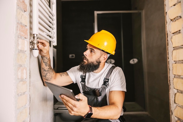 Un trabajador revisando las tuberías de calefacción en un edificio en proceso de construcción