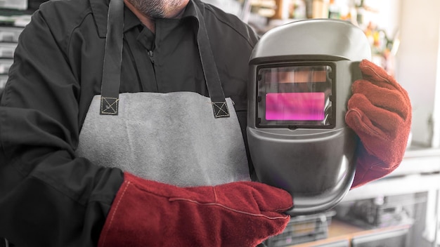 Trabajador con ropa especial y casco trabaja como soldadora en su taller