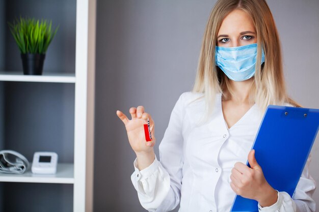 El trabajador de la salud sostiene un tubo de ensayo con una prueba de covid-2019.