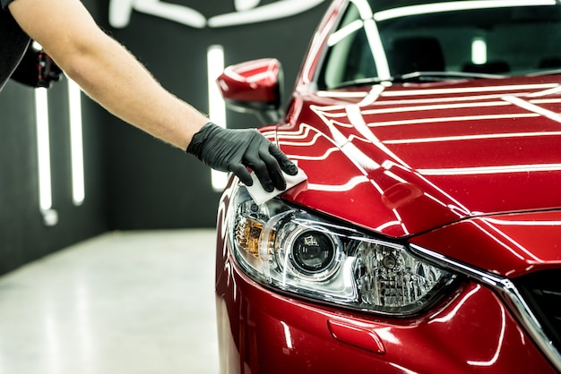 Trabajador de servicio de automóviles aplicando un nano recubrimiento en un automóvil