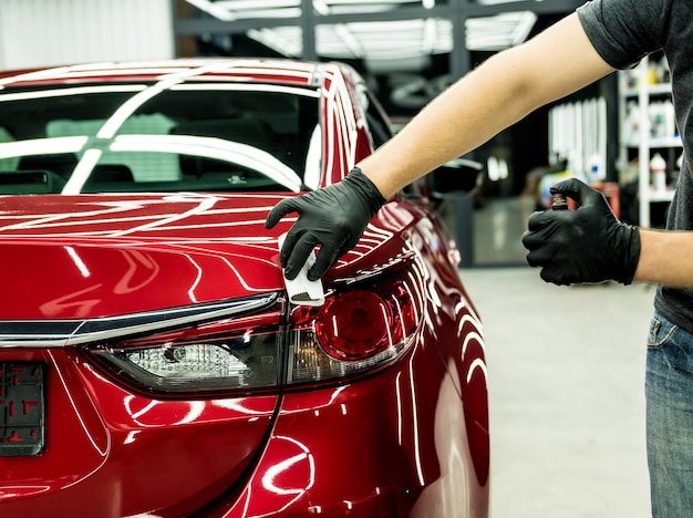 Trabajador de servicio de automóviles aplicando un nano recubrimiento en un automóvil