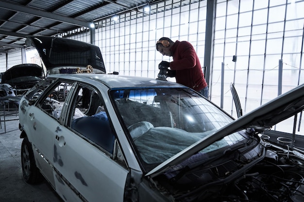 Trabajador de servicio de automóviles reparaciones restaura automóviles