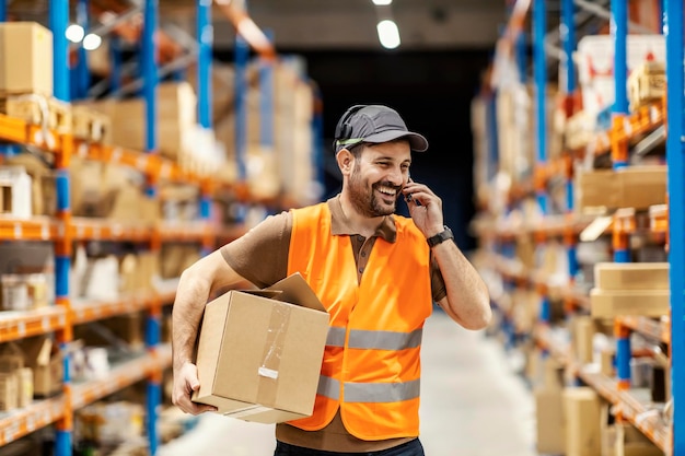 Un trabajador del servicio de entrega que usa un auricular de recolección de voz mientras retiene el envío