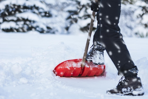 Trabajador del servicio público o ciudadano paleando nieve durante una fuerte ventisca de invierno