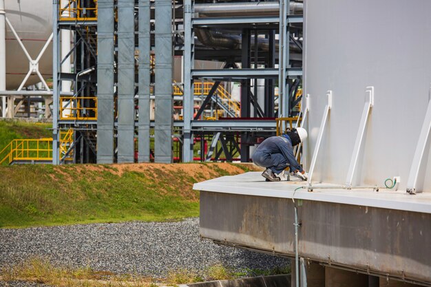 Trabajador de sexo masculino industria inspección visual tanque de almacenamiento de gas propano