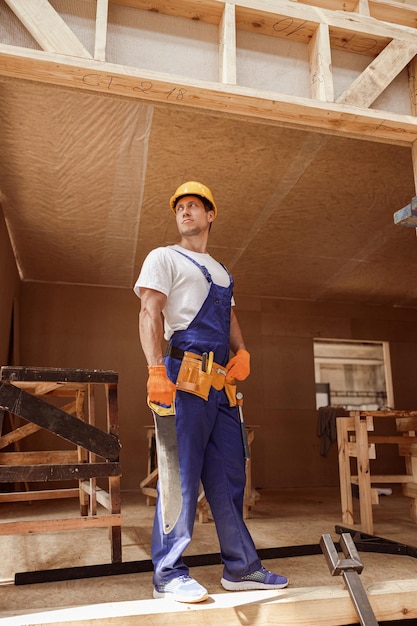 Trabajador de sexo masculino que se coloca en el sitio de construcción de la construcción de viviendas