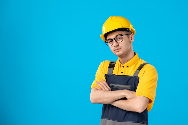 Trabajador de sexo masculino de vista frontal en uniforme amarillo sobre azul