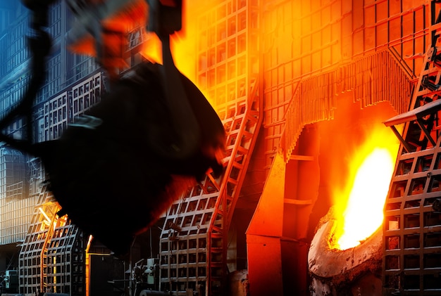 Trabajador siderúrgico en el trabajo de vertido de metal en el taller