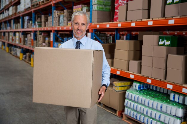 Trabajador Smilng sosteniendo cajas