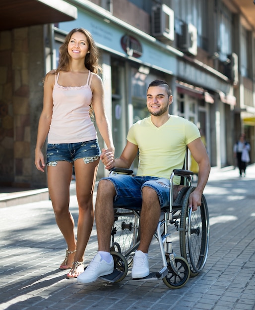 Trabajador social tomando inválido a dar un paseo