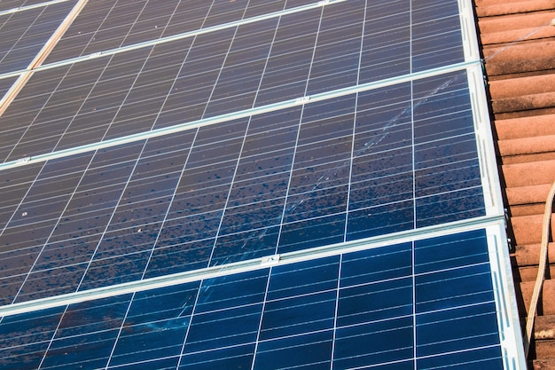 Trabajador solar limpiando paneles fotovoltaicos con cepillo y agua. Limpieza fotovoltaica.