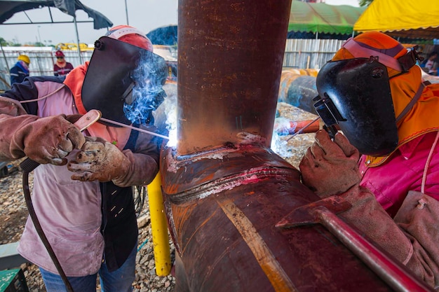 Trabajador de soldadura de metal es parte de la construcción de tuberías de boquilla de maquinaria