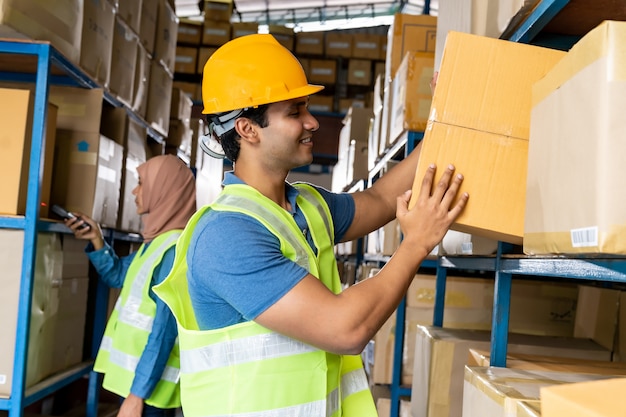 El trabajador sosteniendo una caja en el almacén.