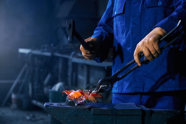 Trabajador sosteniendo un martillo y creando metal