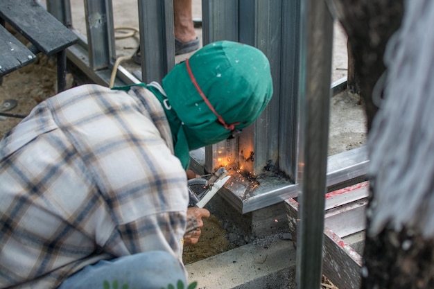 Trabajador suelda la estructura de acero en el sitio de construcción