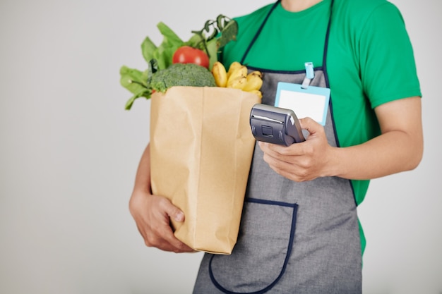 Trabajador de supermercado llevando abarrotes